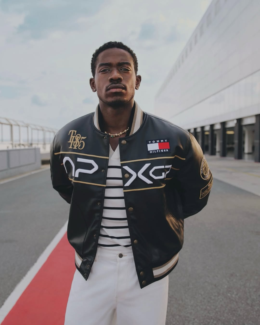 damson idirs wearing black designer tommy hilfiger men's bomber jacket with white pants