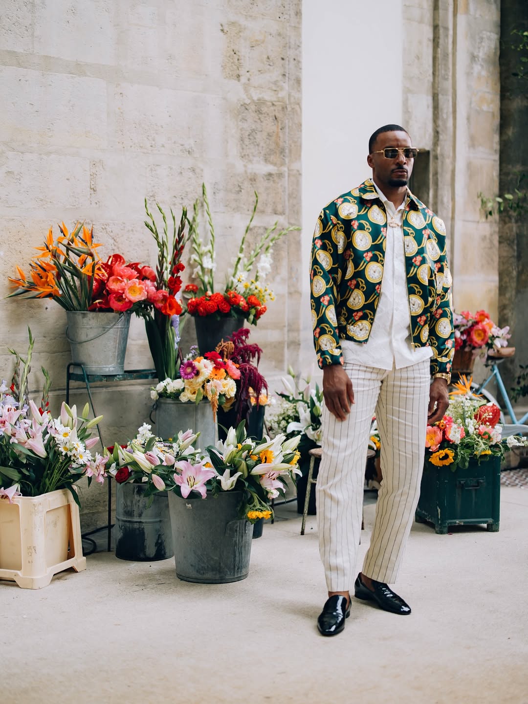 man wearing printed jacket with pin-stripe pants and dress shoes