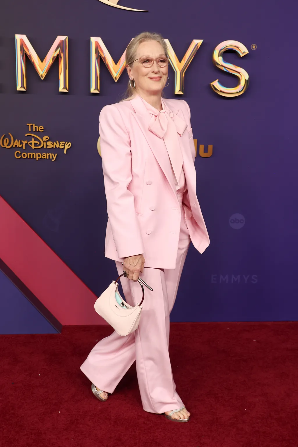 Model wearing a head-to-toe powder pink summer outfit with tailored blazer and pants