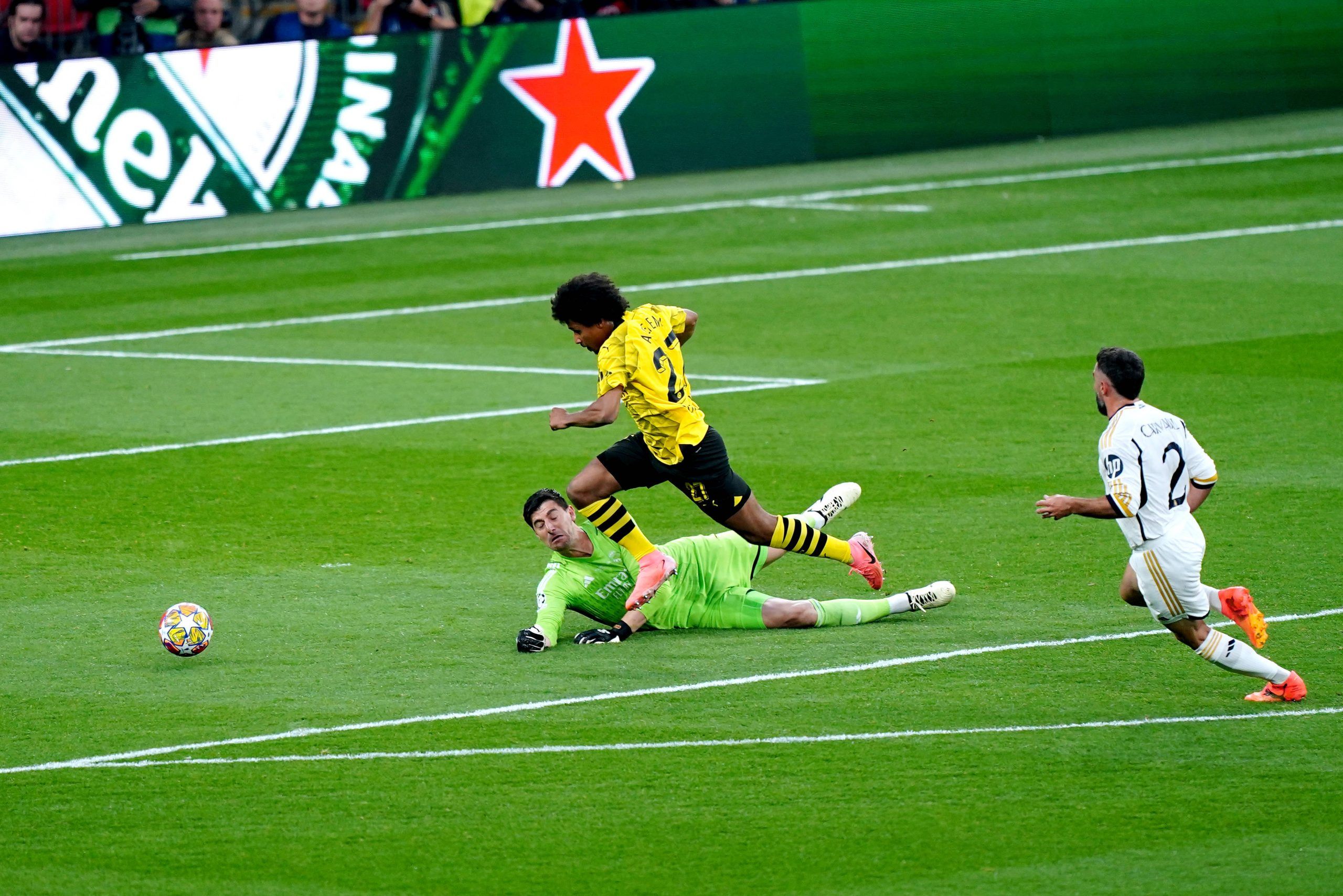 Karim Adeyemi evades Real Madrid goalkeeper Thibaut Courtois during UEFA Champions League final