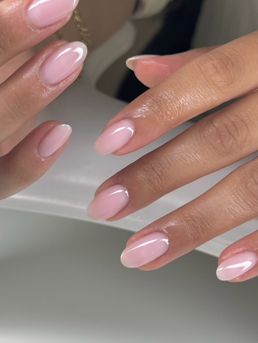 Close-up of powder pink nails and glossy powder pink lipstick