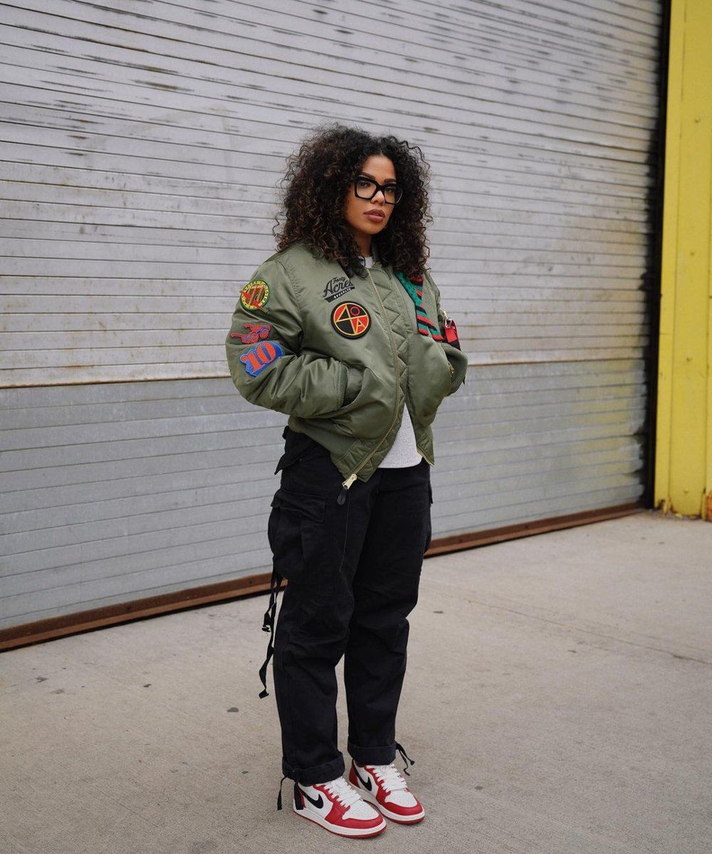 woman wearing black cargo pants with green puffer jacket and sneakers
