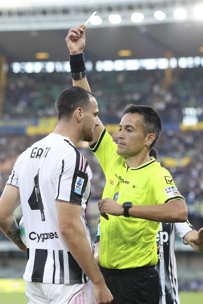 Referee Antonio Rapuano shows yellow card to Federico Gatti in Hellas Verona FC vs Juventus FC