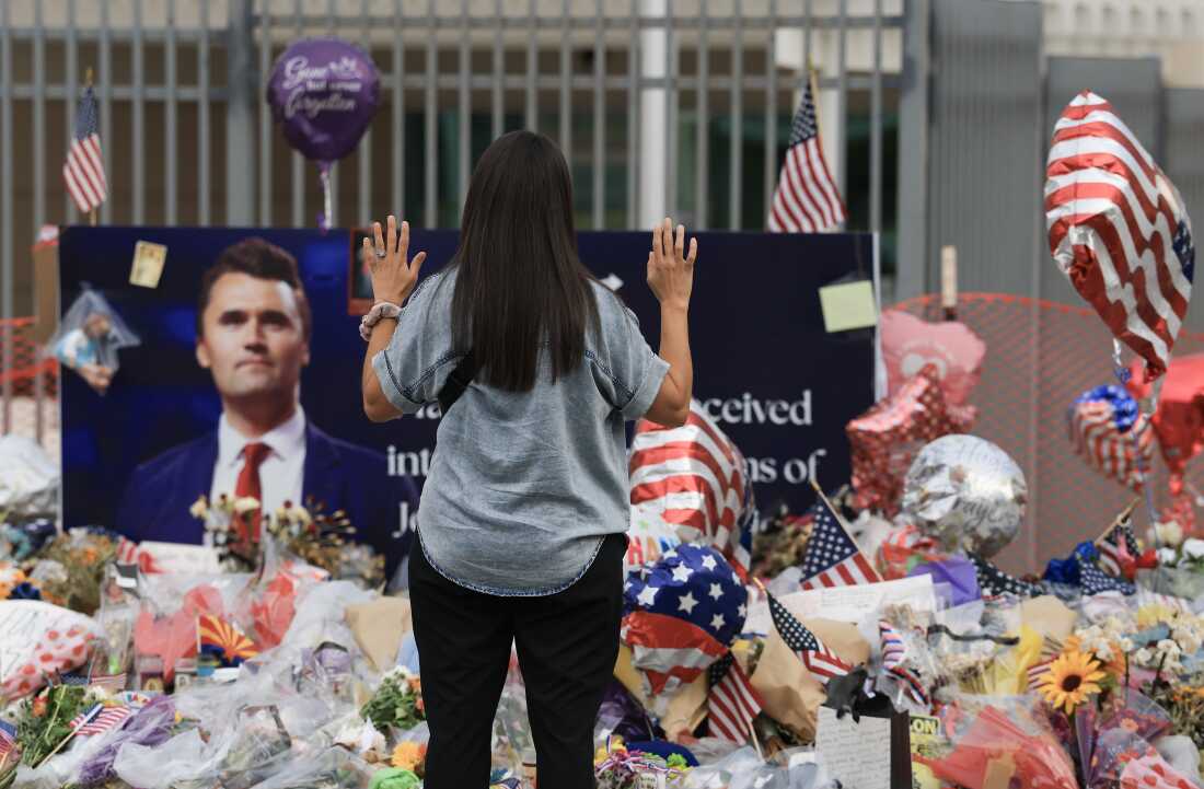 A supporter prays at the makeshift memorial for Charlie Kirk outside Turning Point USA headquarters in Phoenix, Arizona, Sept. 18, 2025