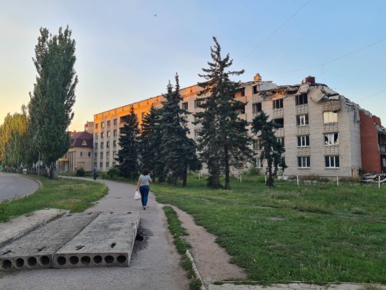 A resident of Sloviansk walks past a building damaged by Russian shelling-1758116295