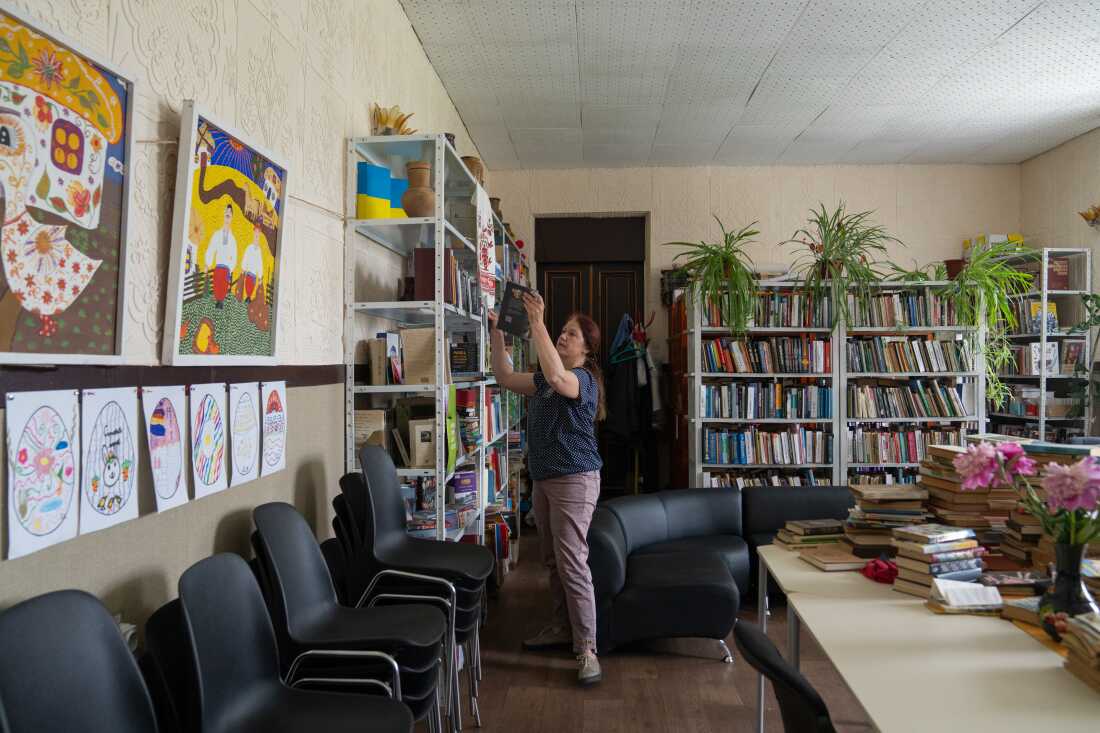 A librarian in Hubynykha, a village where East SOS trainings are conducted, selects books aimed at helping the community understand veterans' experiences.