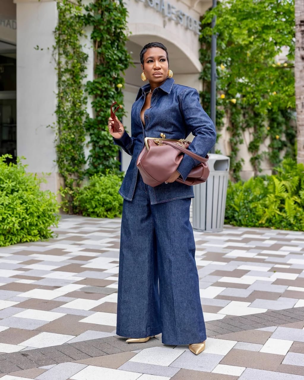 woman wearing double denim outfit with brown leather tote bag