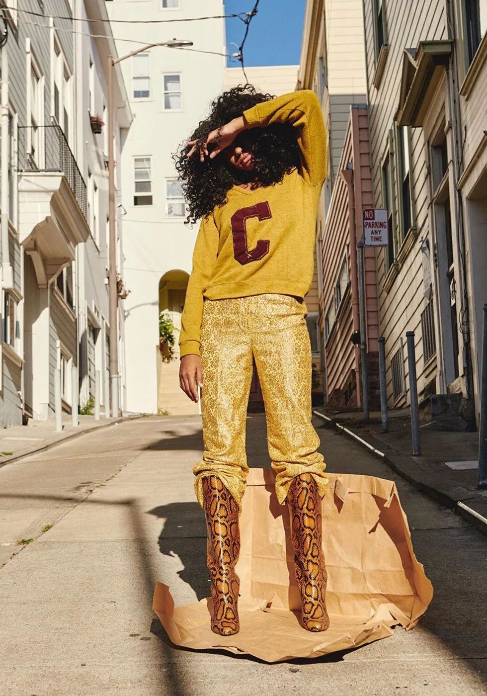 woman wearing yellow sweater with pants and orange snakeskin boots