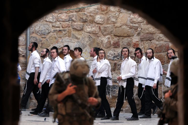 Israeli security forces stand guard as Israeli settlers tour the old market on the Palestinian side of Hebron in the occupied West Bank
