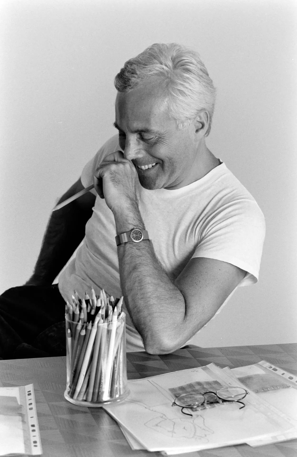 Giorgio Armani in his studio working on designs, symbolizing his rise to fashion icon status.