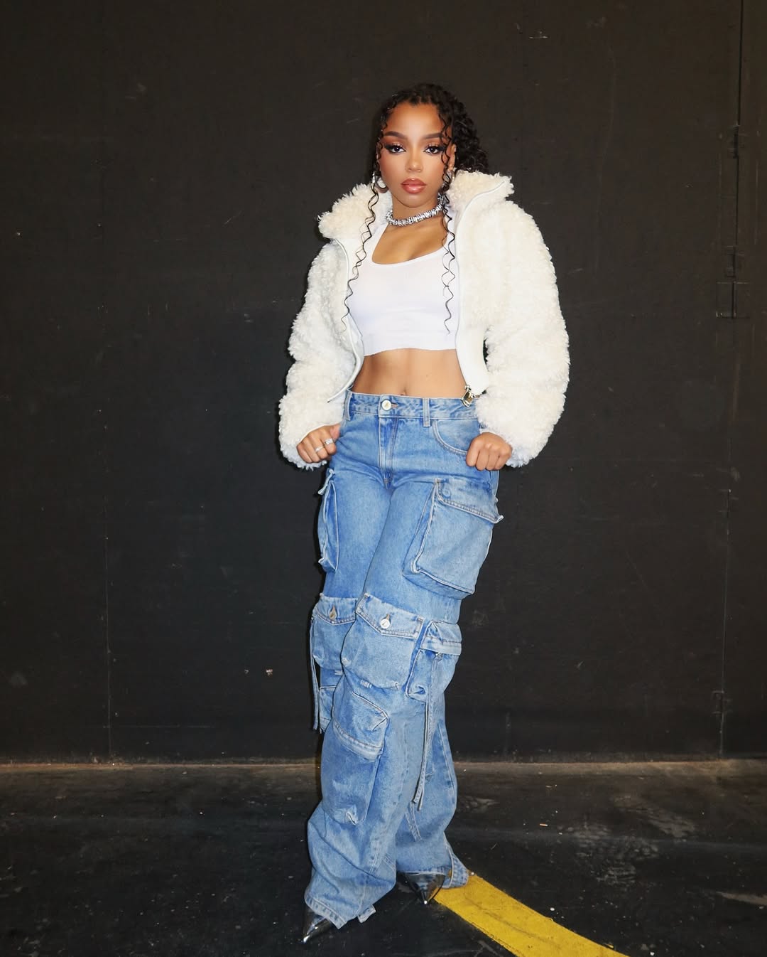 chloe bailey wearing cargo jeans with cropped jacket and white cropped top
