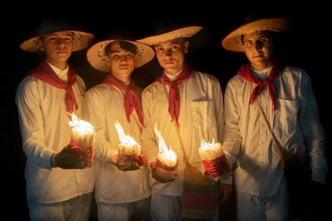 From left to right: Diomar Trigos, Esneider Páez, Humberto Cañizares, and Sebastián Suárez stand on a street after the Pocabuyano Parade in El Banco, Magdalena, Colombia, during the National Festival of Cumbia on October 15, 2022. They represent San Alberto, Cesar, wearing traditional cumbia attire.