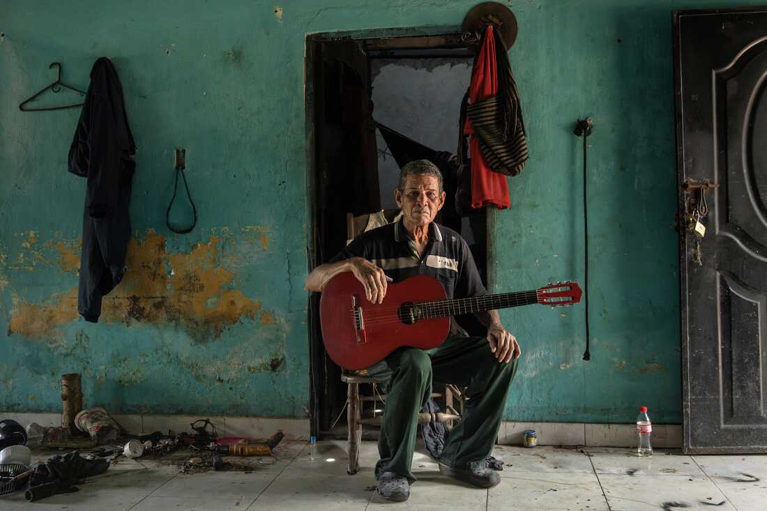 José Benito Africano Mendoza poses with his guitar inside his home in El Banco Magdalena, Colombia, on August 7, 2022. He composes and performs cumbias, including 