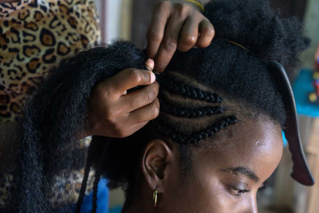 Elida Cañates braids hair extensions on Suleidis Villegas on August 4, 2022, in Palenque de San Basilio, Colombia. The hairstyle, called 