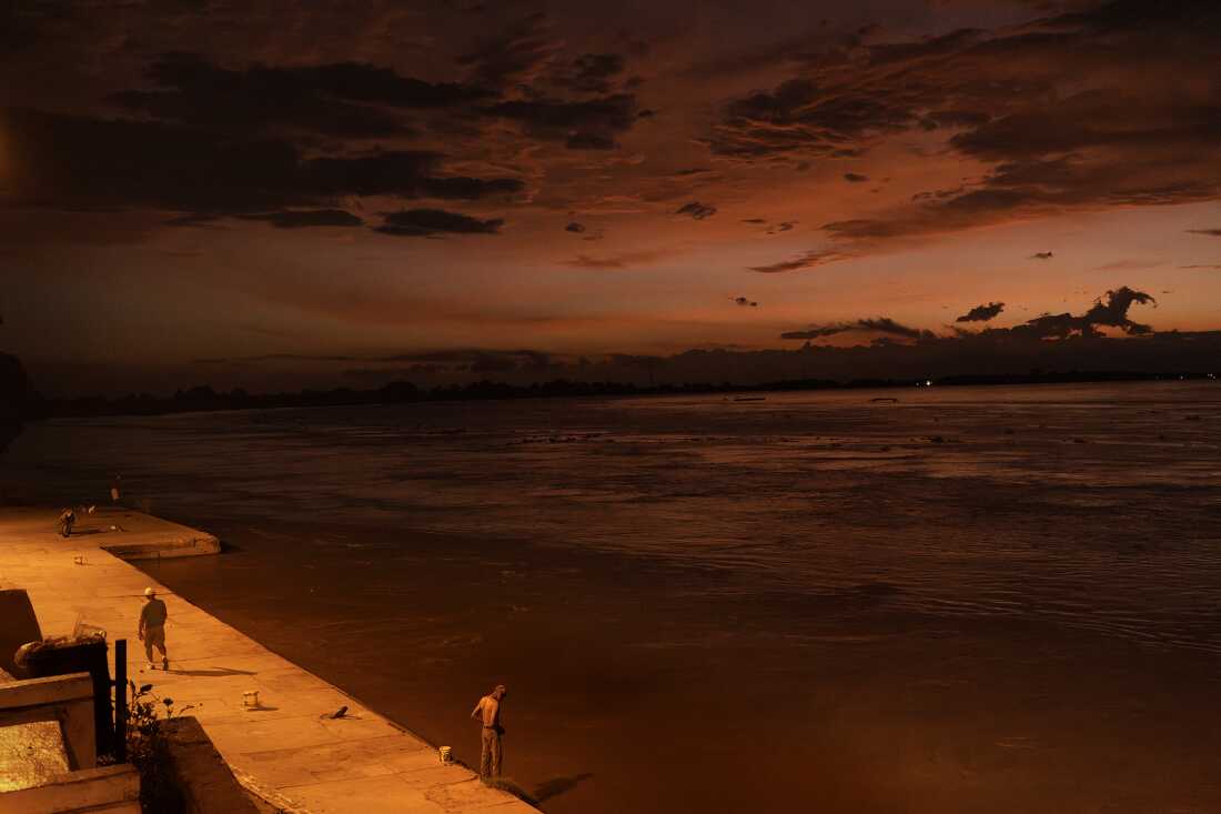 Sunrise over the dock and Magdalena River in El Banco Magdalena, Colombia, on August 9, 2022. The local culture, including cumbia, is deeply intertwined with the river and the fishing community. El Banco and its surroundings along the Magdalena River are considered the birthplace of cumbia. The National Festival of Cumbia, held in El Banco Magdalena, was established in 1968 to honor composer José Benito Barros Palomino.