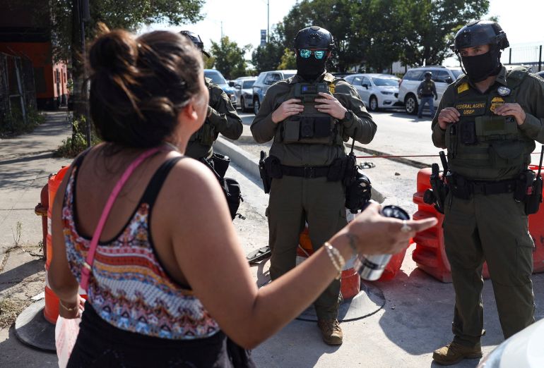 A woman speaks to law enforcement officers during a standoff with U.S. Immigration and Customs Enforcement (ICE) and <a href=