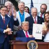 President Donald Trump signs the One, Big Beautiful Bill Act into law on July 4, 2025, in Washington, DC, surrounded by Republican lawmakers.