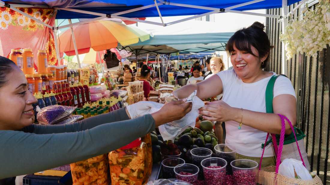 Karla Tatiana Vasquez buying avocados at the Salvadoran Street Food Market in Los Angeles, California, on Sept. 6, 2025.