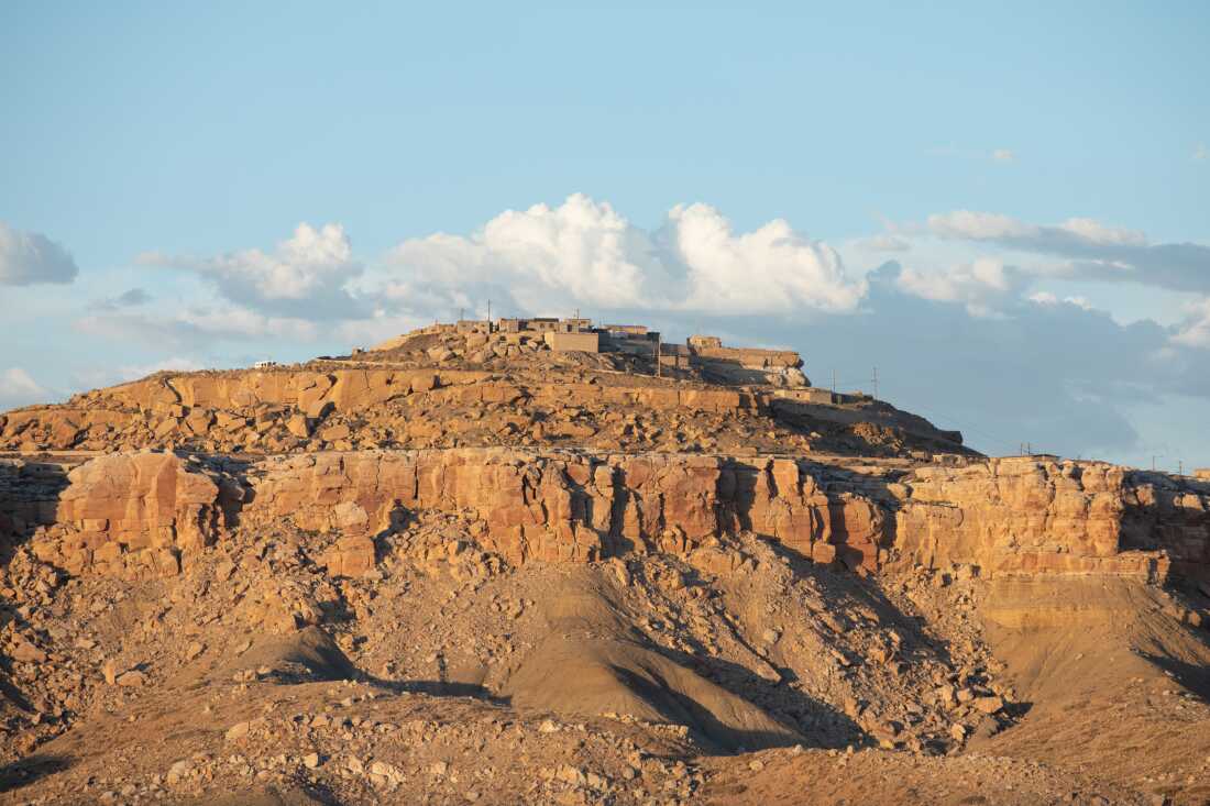 Village atop a mesa on the Hopi Reservation with brown boxlike buildings