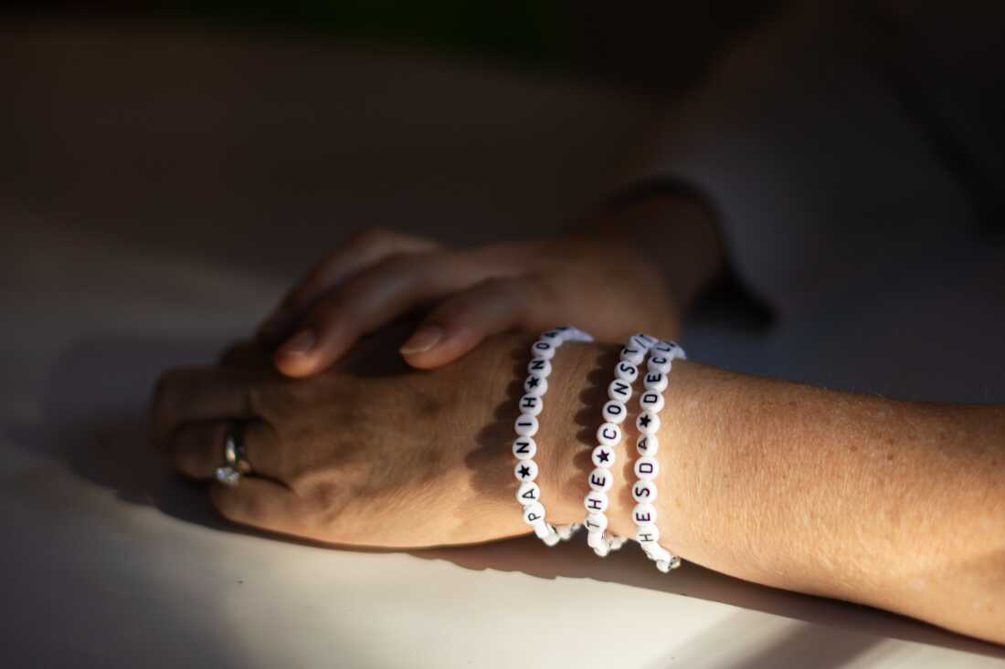 Jenna Norton wearing bracelets supporting federal agencies including NIH and EPA.