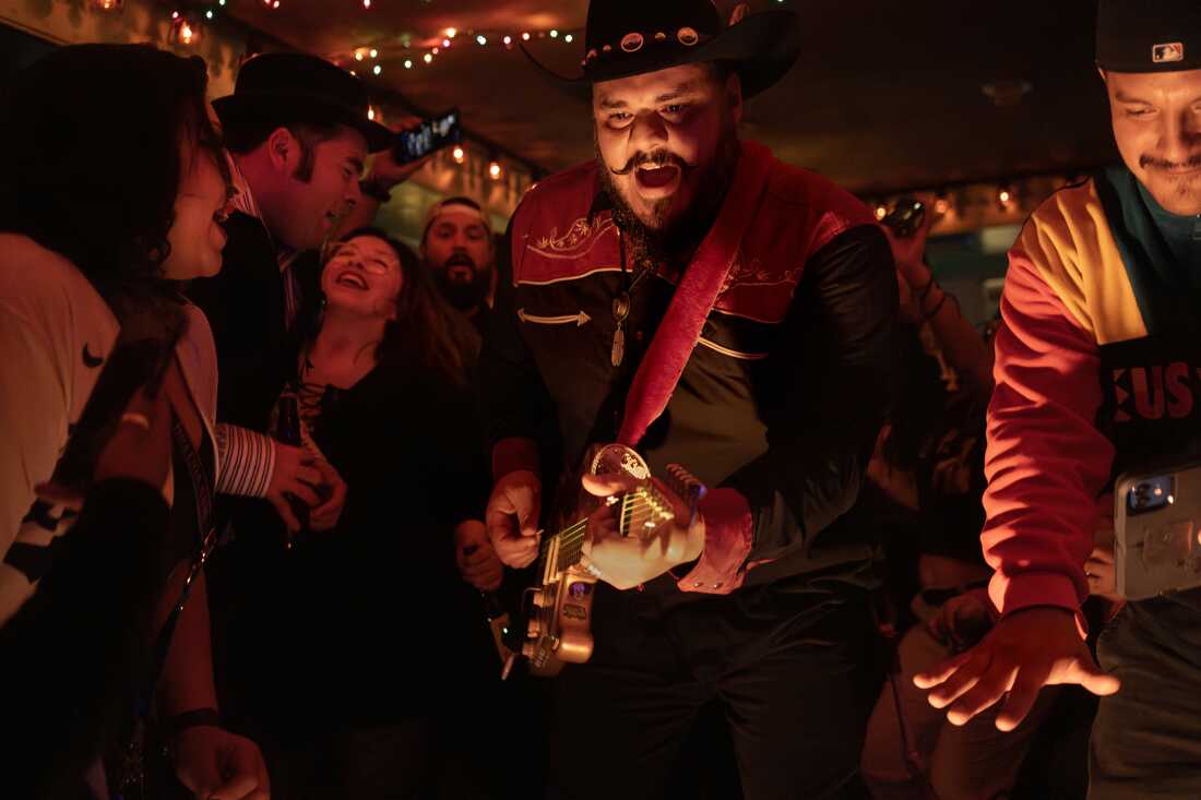 Pedro Zapata tocando guitarra rodeado de público en Las Perlas, marzo 2023.