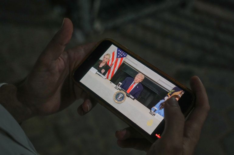 Palestinian paramedic Saeed Awad viewing an image of US President Donald Trump on his phone