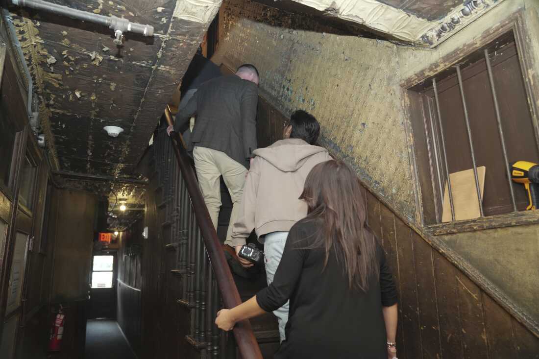 Students and teachers ascend an old staircase at the Tenement Museum. Kat Lloyd encourages use of the original banister.