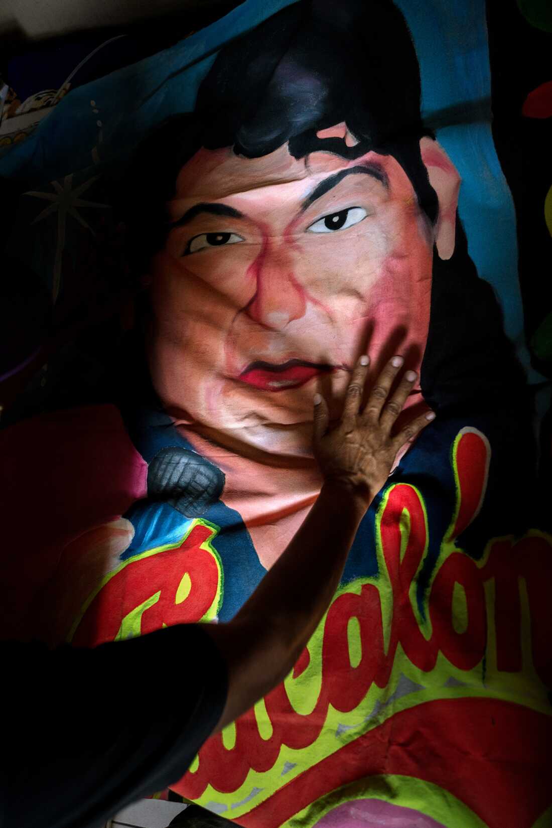 Alfredo Villar Luquin, a writer deeply engaged with chicha culture, places his hand on a painting of Chacalón by Monky in his home on November 11, 2024. Chacalón was instrumental in popularizing chicha in Lima.