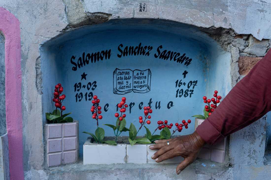Helner Misael Sánchez Casanova, aka Tacto, a member of Los Wembler's de Iquitos, visits the grave of his father Salomon Sánchez Saavedra at Lima's El Sauce cemetery on October 28, 2024. Salomon founded the band with his five sons in 1968.