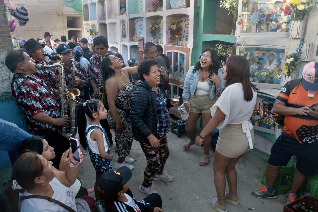 Four saxophonists from Huancayo perform huayno music as a family dances in Lima's El Sauce cemetery on All Saints' Day, November 1, 2024. Huayno combined with Colombian cumbia to form chicha.