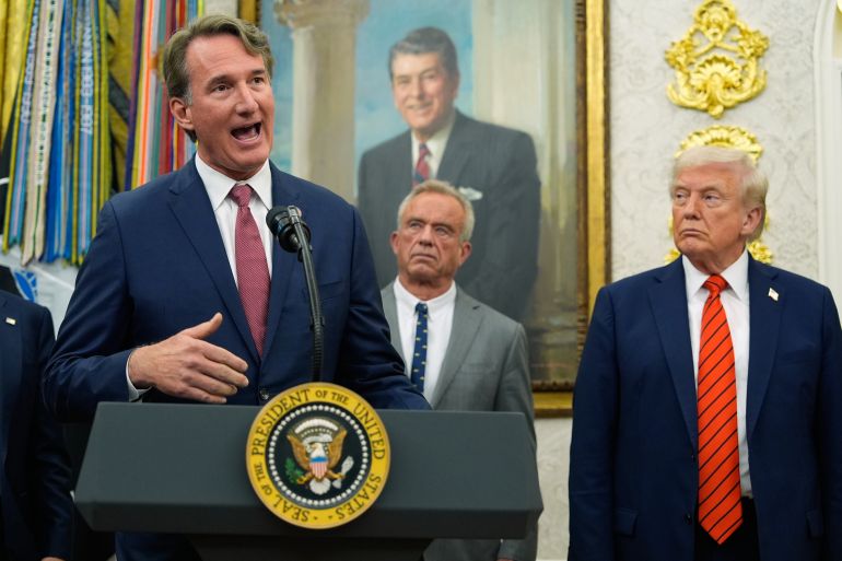 Glenn Youngkin speaks at the Oval Office as Trump looks on.
