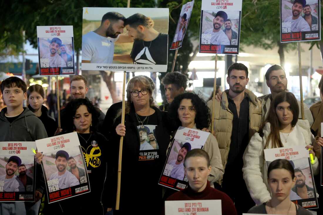 Twins holding portraits of Gali and Ziv Berman, abducted by Palestinian militants during the October 7 attack, at a rally in Tel Aviv calling for their release