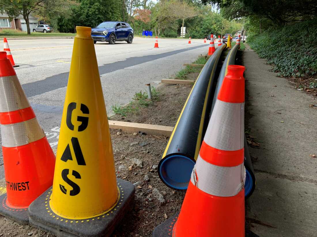 Stacks of new gas pipes with traffic cones along a street in Wyncote, Pennsylvania.