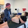Obstetrician-gynecologist performing ultrasound on pregnant patient