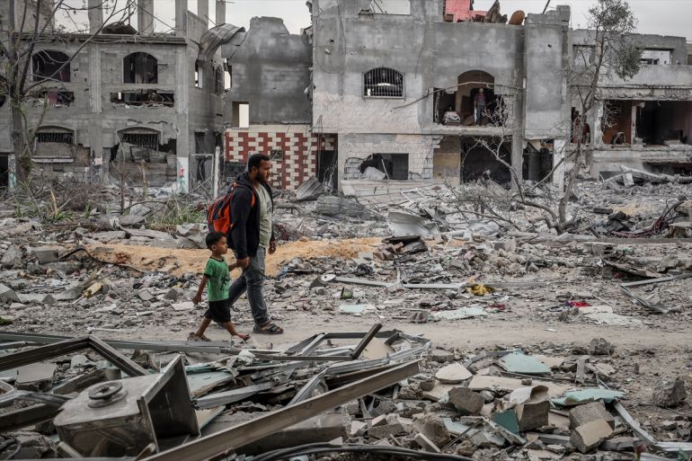 Displaced Palestinians walking among rubble in Gaza after ceasefire