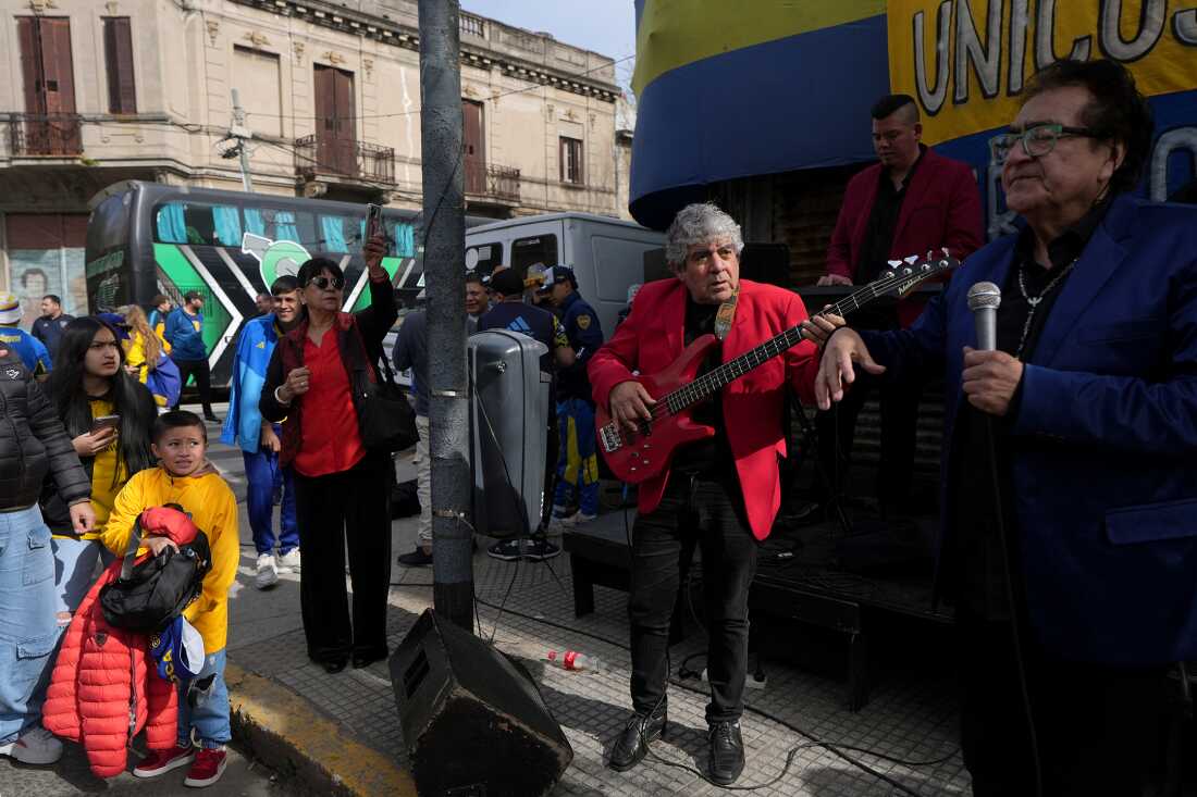 Celebración previa a un partido de fútbol en La Bombonerita, barrio de La Boca, Buenos Aires, con bandas de cumbia animando la calle.