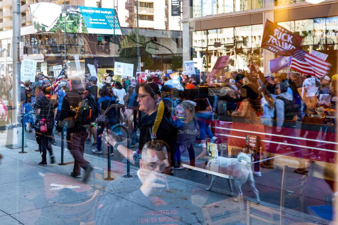 Onlookers observe from Sam's No. 3 diner as protesters march along 15th Street in downtown Denver.