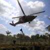 Police rappel from a helicopter to dismantle a cocaine processing lab in Puerto Concordia, Meta state, Colombia.