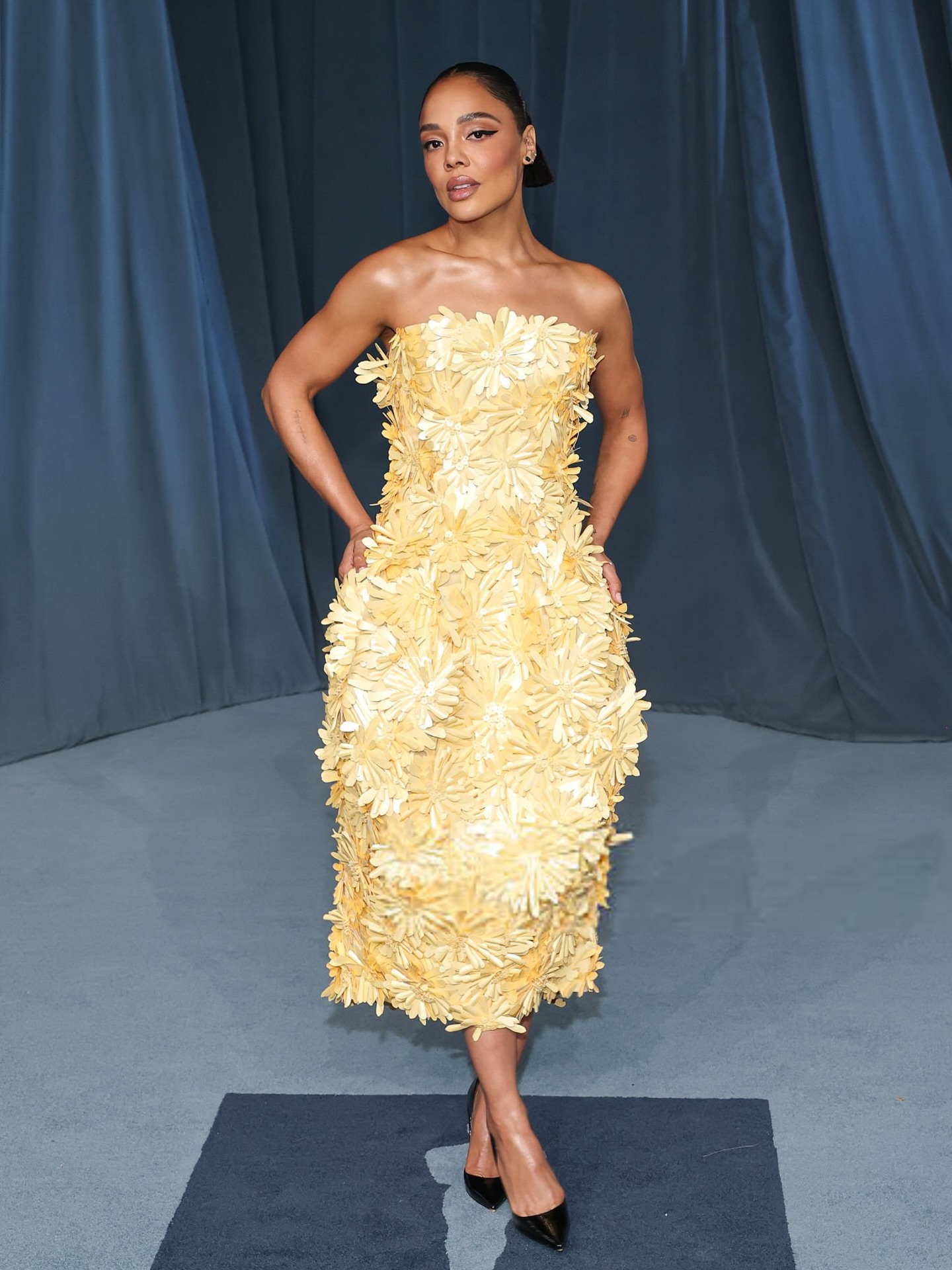 Tessa Thompson in a marigold-yellow Balenciaga gown featuring sculptural tailoring at the 2025 Academy Museum Gala red carpet.