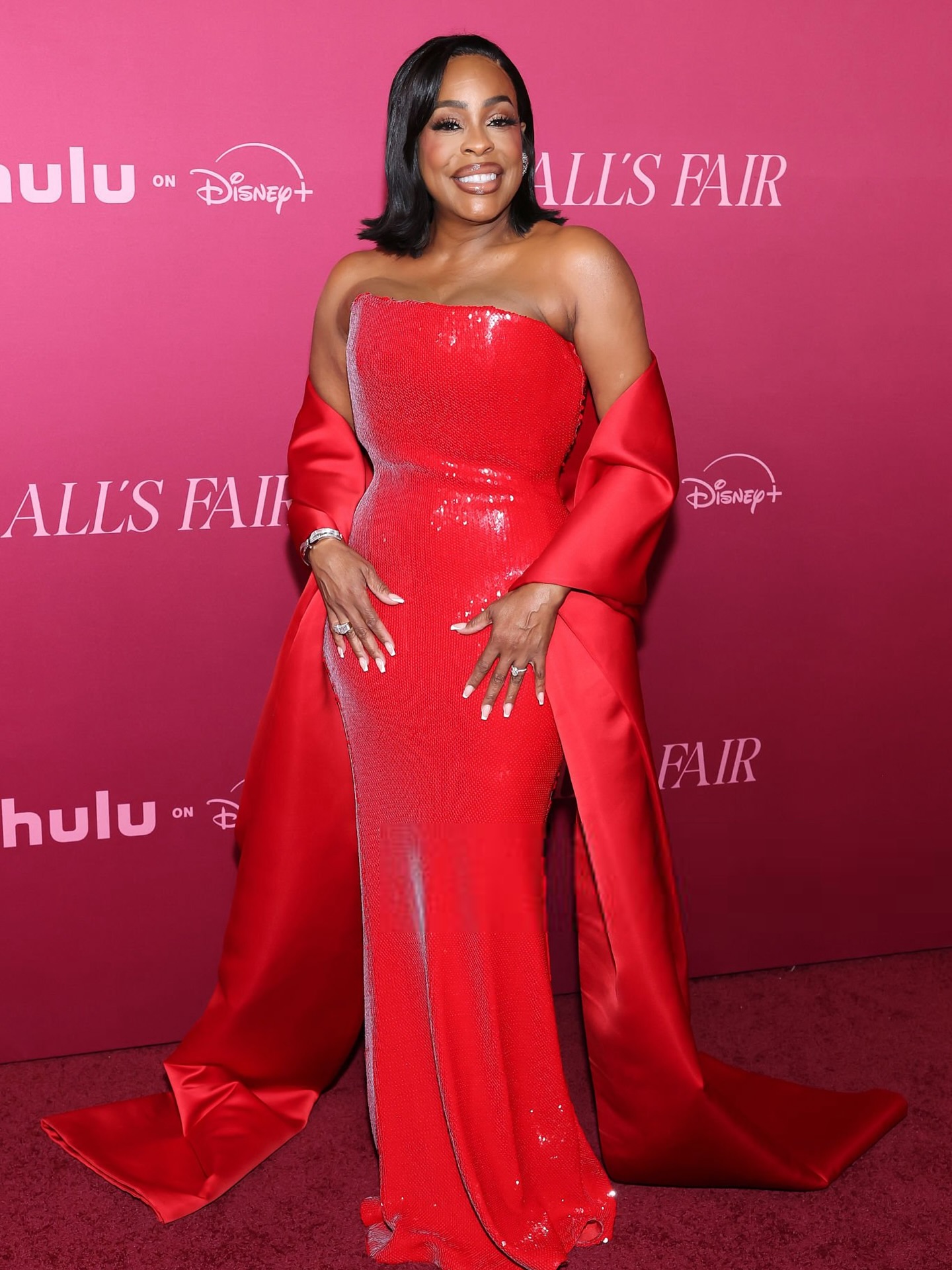 Niecy Nash wearing a bold Sergio Hudson ensemble at the All's Fair premiere in Los Angeles, striking a glamorous pose on the red carpet.