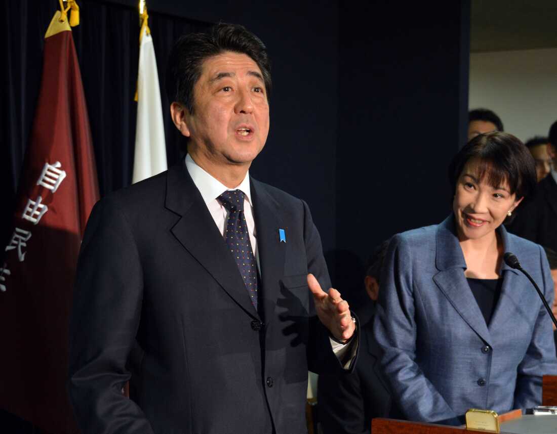 Takaichi listens as incoming Prime Minister Shinzo Abe addresses the media in Tokyo, 2012.
