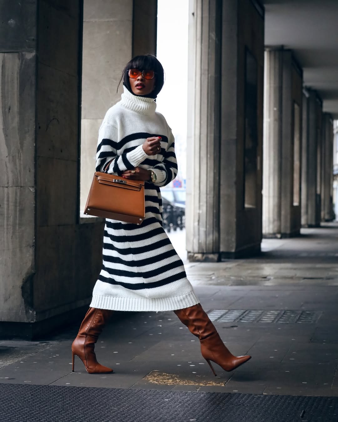 woman wearing modest sweater dress with leather boots