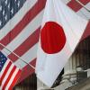 The flag of Japan (right) hangs outside the New York Stock Exchange on May 5, 2008, in honor of Ryozo Kato, the ambassador of Japan to the United States at the time, ringing the opening bell.