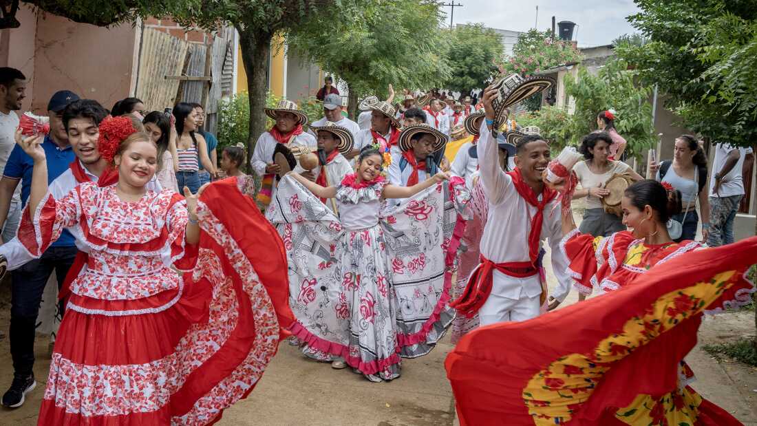 Grupos gaiteros, bailarines y público en general, desfilan hacia el cementerio de San Jacinto, Colombia, el 14 de agosto de 2022.