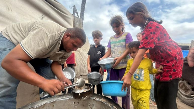 Tawfiq al-Najili distributing food to children