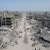 People walk amid the destruction in Gaza City on Oct. 11, 2025, a day after a ceasefire took effect. Israel declared a ceasefire in Gaza and began to pull back its forces on Oct. 10, and tens of thousands of Palestinians made their way back to their devastated homes.