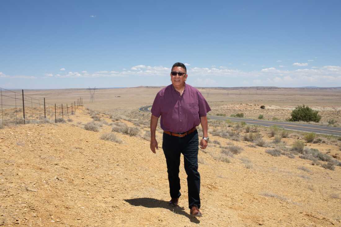 Hopi Chairman Tim Nuvangyaoma walking through a sunlit desert landscape